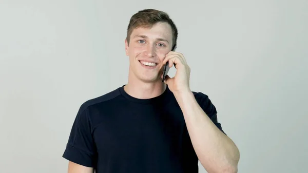 Feliz joven sonriente hablando en móvil aislado sobre fondo blanco —  Fotos de Stock