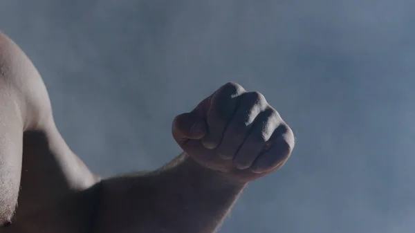 Человек в боксёрских перчатках. Молодой боксёр на чёрном фоне. Боксёр готов к бою. Силовые тренировки и бокс. Крупный план руки боксера, готового к бою . — стоковое фото