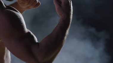 Savaşçı siluet. Yakışıklı atletik adam boks standında karanlık bir arka plan üzerinde. Kas genç adam boks eldivenleri ve şort farklı hareketleri ve grevler gösterir