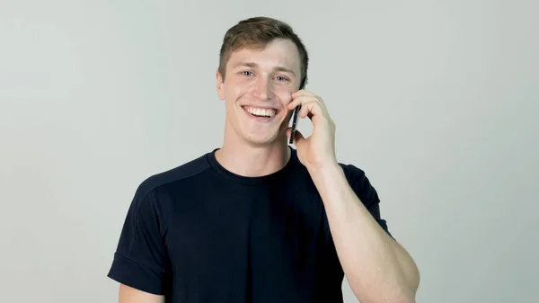 Boldog mosolygós fiatalember beszél mobil elszigetelt fehér háttér — Stock Fotó