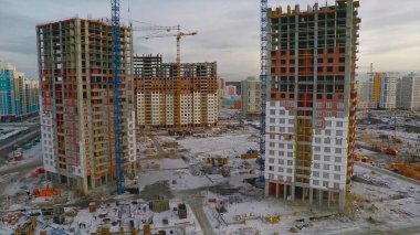 Güneş ışığı altında sarı inşaat Vinçli bina inşaat yüksek altında. daire blok inşaat alanında. Vinç bina ve inşaat mavi gökyüzü altında bina