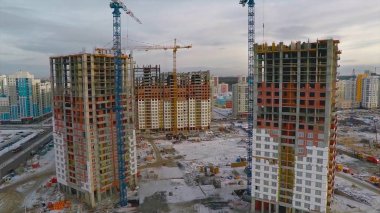 Güneş ışığı altında sarı inşaat Vinçli bina inşaat yüksek altında. daire blok inşaat alanında. Vinç bina ve inşaat mavi gökyüzü altında bina