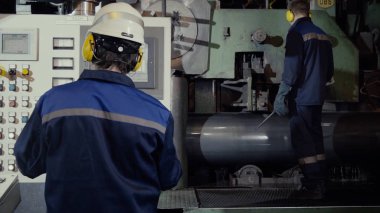 Üretim iki işçi tartışırken, endüstriyel sahne arka planda ekip olarak bitki. Fabrika makinede iki işçi. Güvenlik ekipmanları makineye kaptırdı dışarı ile çalışan