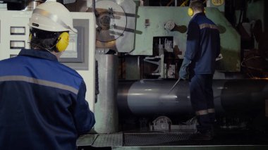 Üretim iki işçi tartışırken, endüstriyel sahne arka planda ekip olarak bitki. Fabrika makinede iki işçi. Güvenlik ekipmanları makineye kaptırdı dışarı ile çalışan