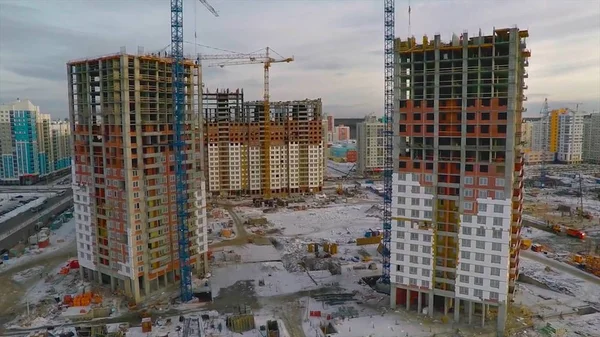 Güneş ışığı altında sarı inşaat Vinçli bina inşaat yüksek altında. daire blok inşaat alanında. Vinç bina ve inşaat mavi gökyüzü altında bina