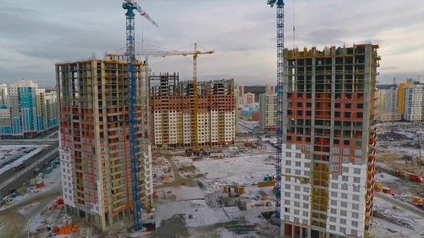 Güneş ışığı altında sarı inşaat Vinçli bina inşaat yüksek altında. daire blok inşaat alanında. Vinç bina ve inşaat mavi gökyüzü altında bina