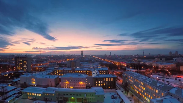 Večerní město v zimě timelapse. Večerní město v zimě pohledu ze střechy timelapse. Panoramatický pohled na město a střechy pod sněhem, timelapse. Světla pouličních noční město — Stock fotografie