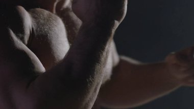 Savaşçı siluet. Yakışıklı atletik adam boks standında karanlık bir arka plan üzerinde. Kas genç adam boks eldivenleri ve şort farklı hareketleri ve grevler gösterir