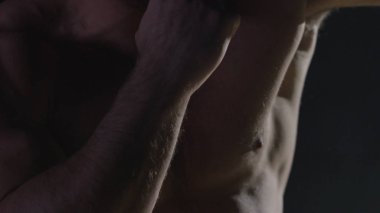 Savaşçı siluet. Yakışıklı atletik adam boks standında karanlık bir arka plan üzerinde. Kas genç adam boks eldivenleri ve şort farklı hareketleri ve grevler gösterir