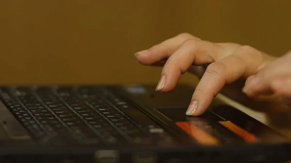 En kvinnas hand med fingrarna på en laptop musmatta. Kvinnans hand med laptop mus — Stockfoto