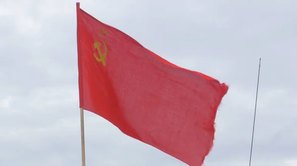 Flaggan av USSREN utveckla i vinden på en flaggstång i en blåsig dag. Flagga av den sovjetiska unionen mot himlen — Stockfoto