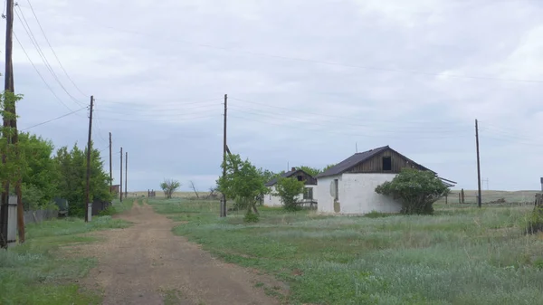 Een oude, verlaten huis in het dorp, op een achtergrond van bomen. Verlaten huis in de buurt van Donetsk. Verwoeste huizen en ruïnes, mechanismen Oekraïne — Stockfoto