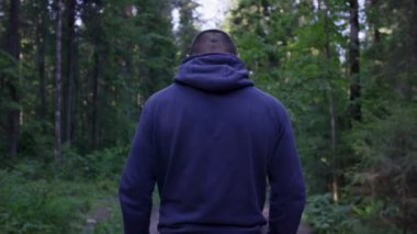 Yüz yüze bir başlık ayakta. Ormanda kapüşonlu adam. Spor niteliğine ormandaki