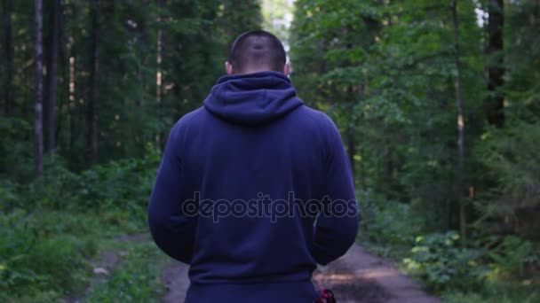 Person mit Kapuze stehend. Mann mit Kapuze im Wald. Sport im Wald in der Natur — Stockvideo