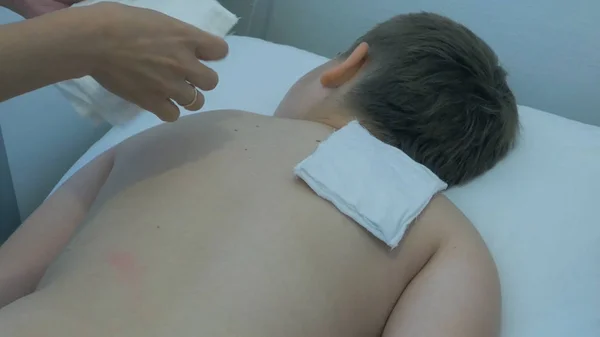 Electro estimulação na fisioterapia. Eletrodos de posicionamento fisioterapeuta para o tratamento da parte inferior das costas. Tratamento de eletrodos TENS nas costas . — Fotografia de Stock