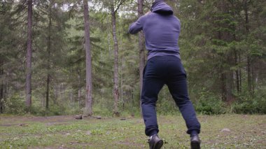 Zıplama, genç atletik erkek güç egzersizleri, crossfit elementini gerçekleştirir. Çam ormanı içinde yaz