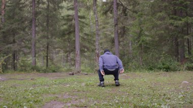 Zıplama, genç atletik erkek güç egzersizleri, crossfit elementini gerçekleştirir. Çam ormanı içinde yaz