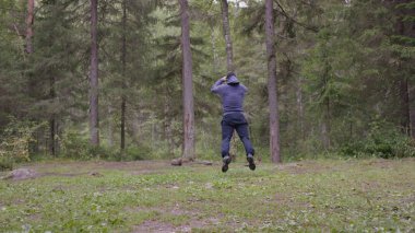 Zıplama, genç atletik erkek güç egzersizleri, crossfit elementini gerçekleştirir. Çam ormanı içinde yaz