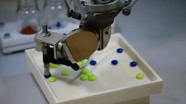 Otomatik robot ilaç endüstrisi. Robot otomatik olarak sıralama topları. Robot hapları rengine göre sıralar.