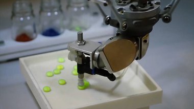 Otomatik robot ilaç endüstrisi. Robot otomatik olarak sıralama topları. Robot hapları rengine göre sıralar.