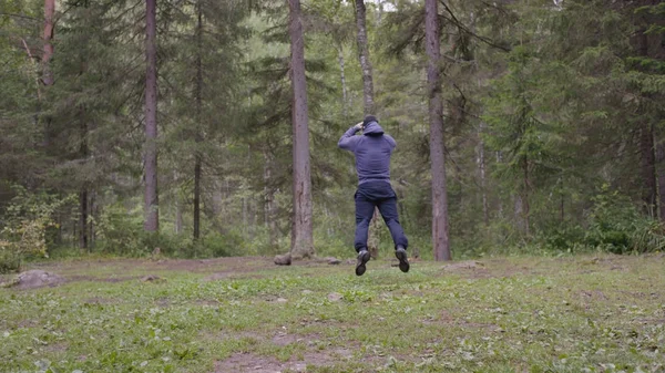 Zıplama, genç atletik erkek güç egzersizleri, crossfit elementini gerçekleştirir. Çam ormanı içinde yaz