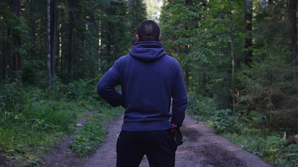 Persona en una capucha de pie. Hombre en el barrio en el bosque. Deporte en el bosque en la naturaleza — Foto de Stock