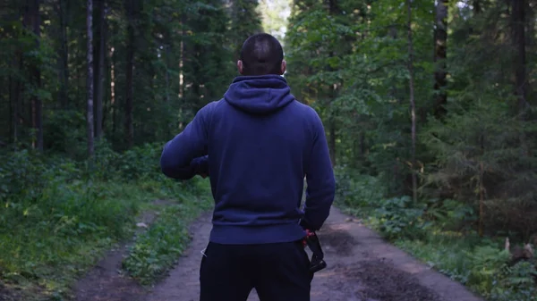 Yüz yüze bir başlık ayakta. Ormanda kapüşonlu adam. Spor niteliğine ormandaki