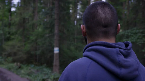 Athletic man with headphones on road through forest. Athletic man standing on trail through autumn forest. Back view — Stock Photo, Image