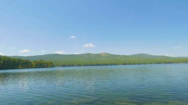 Göl kıyısında güzel mavi temiz su. Orman manzara suda yansıtılmış sahilinde