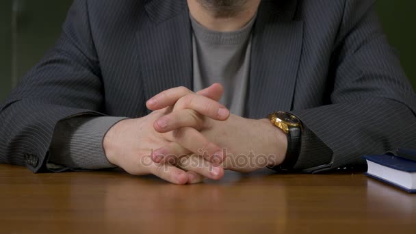 Empresario sentado con los dedos cruzados. Empresario sentado a la mesa con los dedos cruzados — Vídeos de Stock