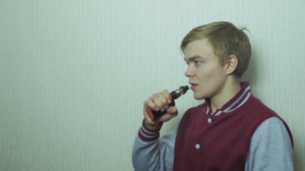 Junger Mann, der elektronische Zigarette raucht. Junger Mann benutzt Dampflokomotive als Raucher-Alternative — Stockvideo