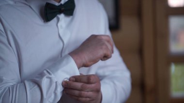 Erkek gömlek kolları üzerinde kadar düğmelerini. Yakın bir el adamın giyer beyaz gömlek ve kol düğmesi nasıl. Adam gömleğinin kol kadar düğmelerini. Kol düğmesi kadar zip. Mens stili.