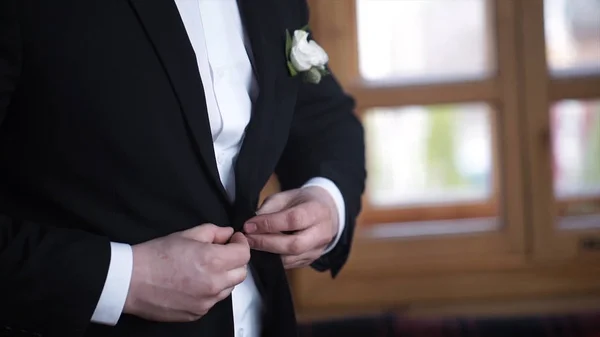 Um homem a abotoar um casaco preto. Detalhes do casamento - elegante noivo vestido traje de smoking de casamento está esperando a noiva. Homem de negócios a abotoar o casaco, a vestir-se. Casaco de botões de noivo — Fotografia de Stock
