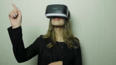 Sanal kulaklık giyen yakışıklı genç kadın. VR gözlükle gülümseyen hippi. Beyaz grunge duvar çatlakları arka plan ile. Havada Vr aygıt ve parmak dokunuşu ile Bayan giyimi.