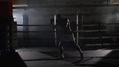 Eğitim yüzüğünü savaşçı çabalıyormuş. Profesyonel savaşçı. Eğitim sporunda erkek boksör, spor salonunda bir egzersiz, halka bir gölge ile mücadele, Strike test