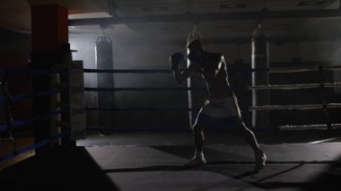 Eğitim yüzüğünü savaşçı çabalıyormuş. Profesyonel savaşçı. Eğitim sporunda erkek boksör, spor salonunda bir egzersiz, halka bir gölge ile mücadele, Strike test