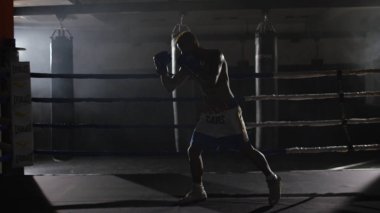 Eğitim yüzüğünü savaşçı çabalıyormuş. Profesyonel savaşçı. Eğitim sporunda erkek boksör, spor salonunda bir egzersiz, halka bir gölge ile mücadele, Strike test