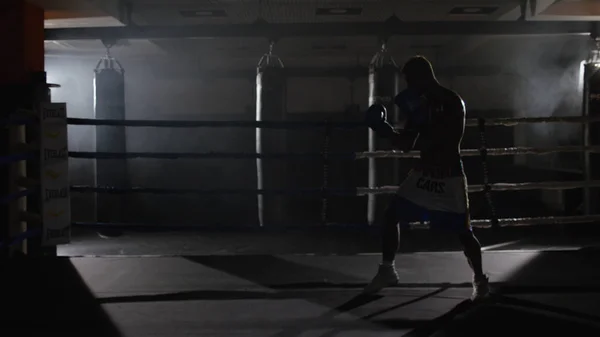 Fighter Shadowboxing på utbildning ring. Professionell fighter. Manliga boxare i utbildning sportkläder, en övning i idrotts Hall, slåss med en skugga i ringen, Strike test — Stockfoto
