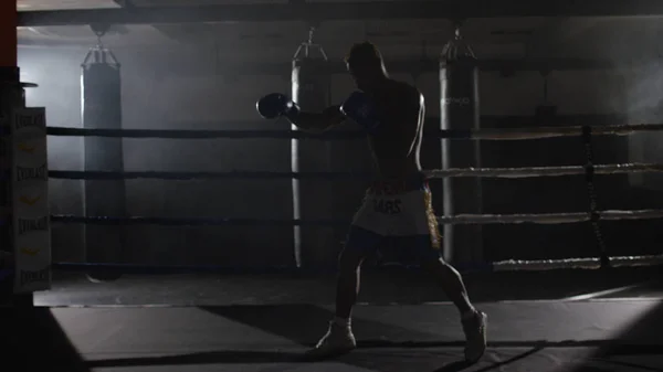 Combattant Shadowboxing sur l'anneau d'entraînement. Combattant professionnel. boxeur masculin en tenue de sport d'entraînement, un exercice dans la salle de sport, se battre avec une ombre dans l'anneau, Strike testing — Photo