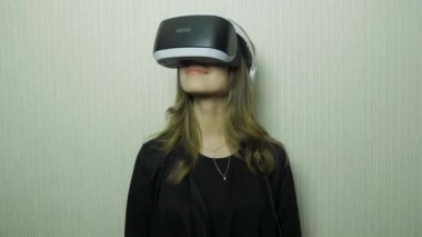 Genç kadın sanal gerçeklik gözlük yaşıyor. VR googles evde kullanmak için genç kadının. Kadın evde bir Vr bardaklarda