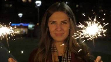 Maytap sokakta tutan genç güzel mutlu gülümseyen kız. Tatil kavramı. Maytap sokakta kızla