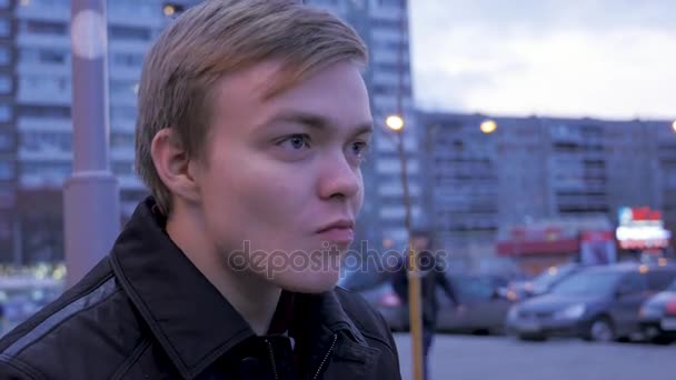 Joven comiendo una sabrosa hamburguesa de comida rápida en la calle hamburguesa. Joven comiendo una hamburguesa en la calle — Vídeo de stock