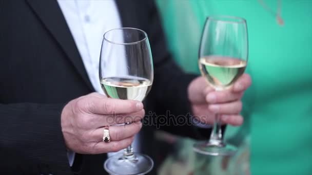 Äldre man står med ett glas champagne. Gubbe med glasögon champagne — Stockvideo