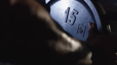 Sıra sıkıştırma için hazırlanıyor. Tebeşir elinde. Bir halter farklı görünümü hazırlanıyor. Dikey olarak çerçeveli bir spor salonunda ağırlık basarak bir atletik, tezgah görüntüsünü kapat