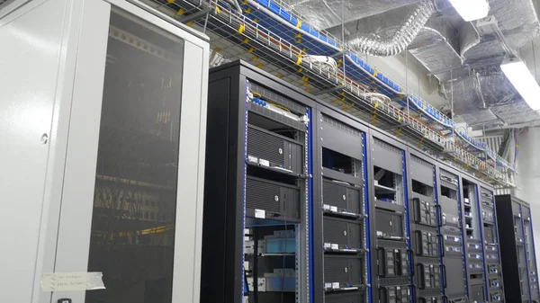 Many powerful servers running in the data center server room. Many servers in a data center. Many racks with servers located in the server room. Bright display a plurality of operating equipment. — Stock Photo, Image