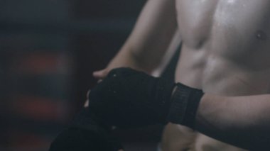 Bir boksör mücadele karanlık bir arka plan üzerinde hazırlama askıları koyarak kapatın. Boksör bandaj boks kırmızı portre erkek el. Fighter fight veya eğitim spor salonunda önce yumruk.