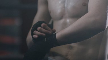 Bir boksör mücadele karanlık bir arka plan üzerinde hazırlama askıları koyarak kapatın. Boksör bandaj boks kırmızı portre erkek el. Fighter fight veya eğitim spor salonunda önce yumruk.