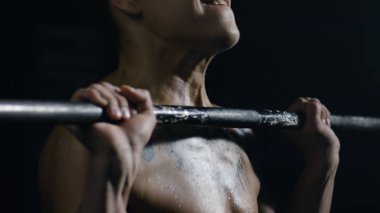 Kas erkek modeli Barbell ile egzersizleri yapıyor. Fit genç adam barbells kaldırma, bir spor salonunda çalışma. Kaldırma Barbell ayakta