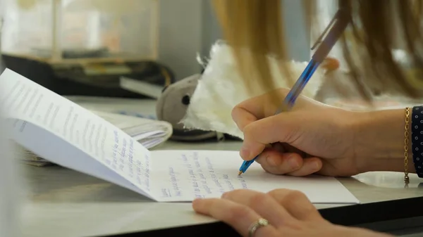 Primer plano de una escritura femenina en un cuaderno en blanco con un bolígrafo. Primer plano de una escritura femenina en un cuaderno en blanco con un bolígrafo — Foto de Stock