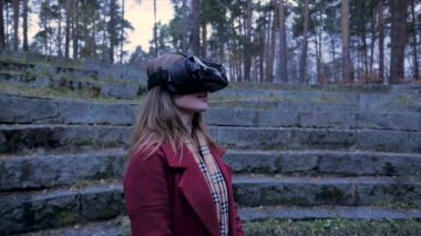 Güzel kız sanal gerçeklik gözlükleri tadını çıkarın. Park açık sanal gerçeklik ile güzel bir kadın. VR kulaklık gözlük aygıt. İnsanlar teknoloji kavramı